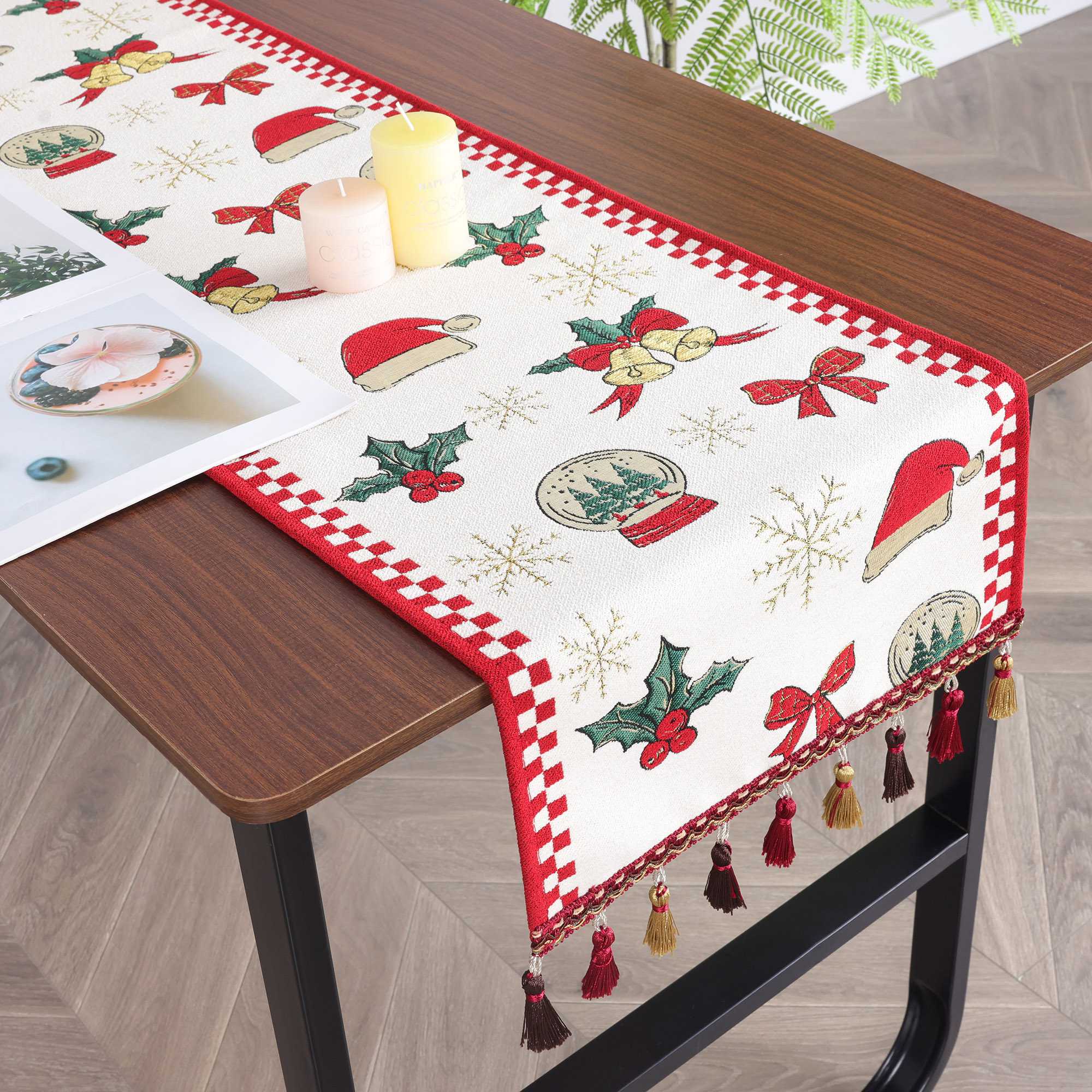 Dieses Bild zeigt einen Weihnachts-Tischläufer, der mit festlichen Motiven wie Weihnachtsmützen, Glocken, Tannenbäumen und roten Schleifen verziert ist. Die lebendigen Farben und das klassische Design schaffen eine warme und fröhliche Weihnachtsatmosphäre. Die edlen Fransen am Rand des Tischläufers verleihen ihm zusätzlichen Charme und Eleganz. In Kombination mit Kerzen und einfachem Geschirr sorgt dieser Tischläufer für eine perfekte Festtagsdekoration, ideal für Familienfeiern und Weihnachtsfeiern.