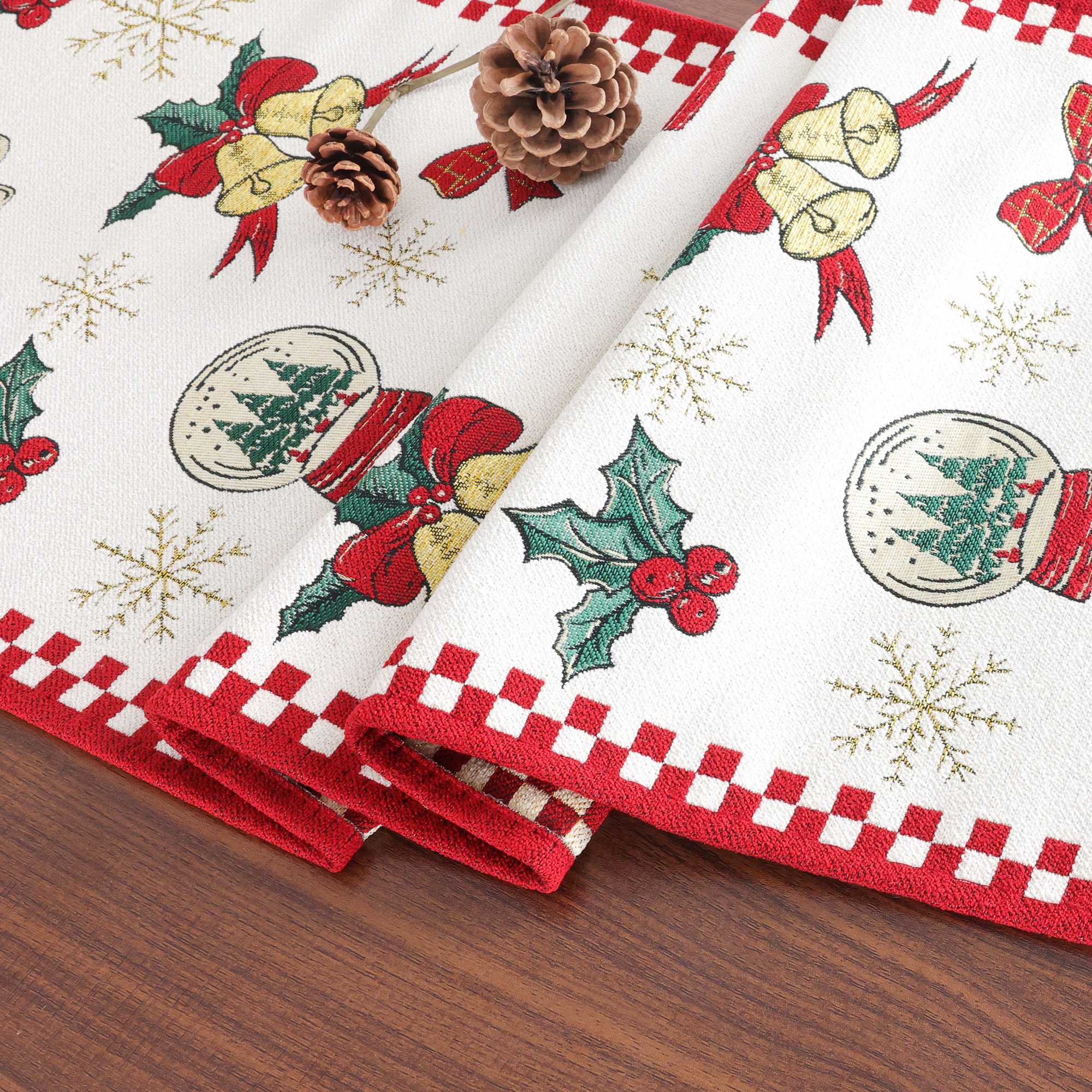 Dieses Bild zeigt einen Weihnachts-Tischläufer, der zusammengefaltet präsentiert wird. Der Tischläufer ist mit klassischen Weihnachtsmotiven wie Glocken, Tannenzweigen, Weihnachtskugeln und Schneeflocken verziert. Der rote Rand und das weiße Hintergrundmuster schaffen einen festlichen und eleganten Look. Die feinen Details und die hochwertige Jacquard-Webtechnik machen diesen Tischläufer zu einem perfekten Accessoire für festliche Tische und Weihnachtsdekorationen.