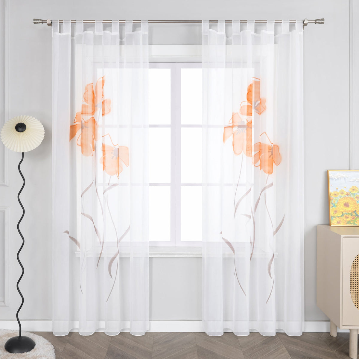 Das Bild zeigt einen Vorhang mit orangefarbenen Blumenmustern. Der Vorhang ist hauptsächlich weiß, wobei die Blumen im Muster orangefarbene und braune Details aufweisen.